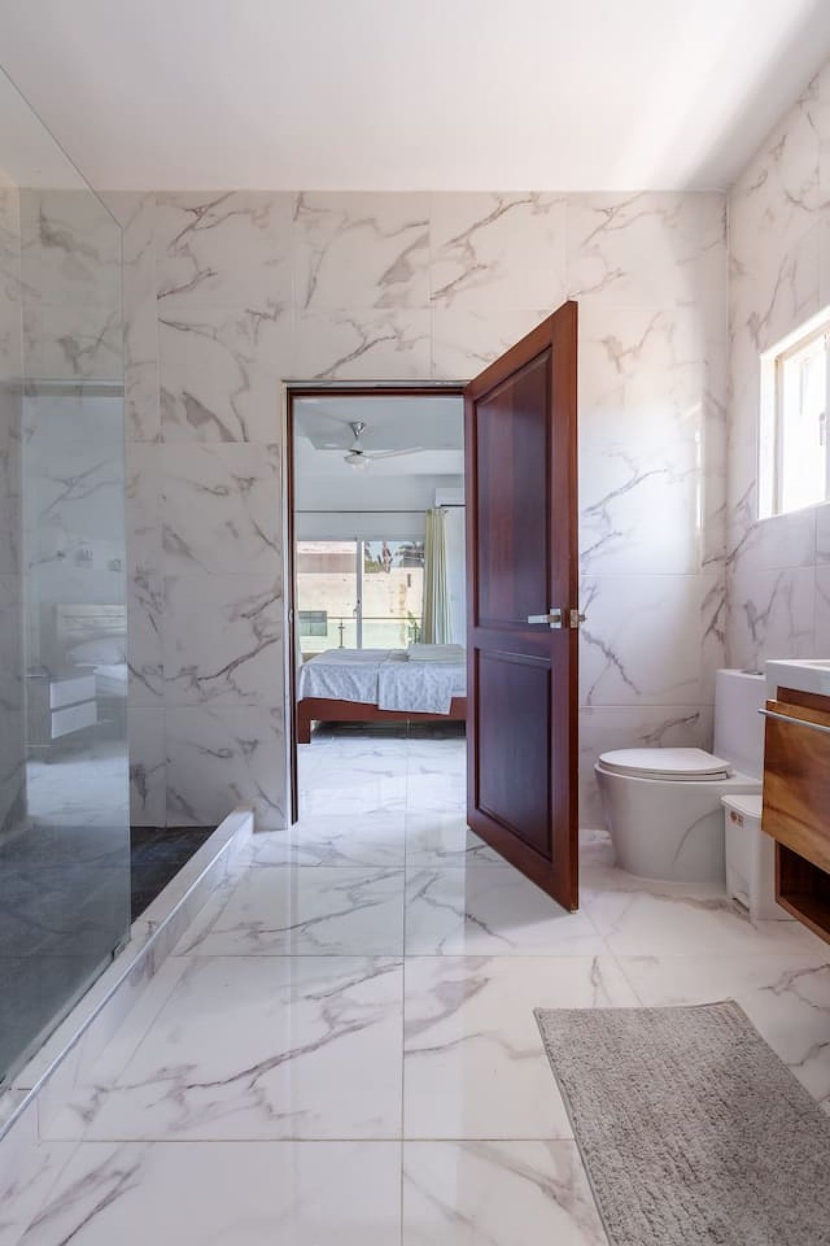 A bathroom with a toilet, a shower, and a sink.