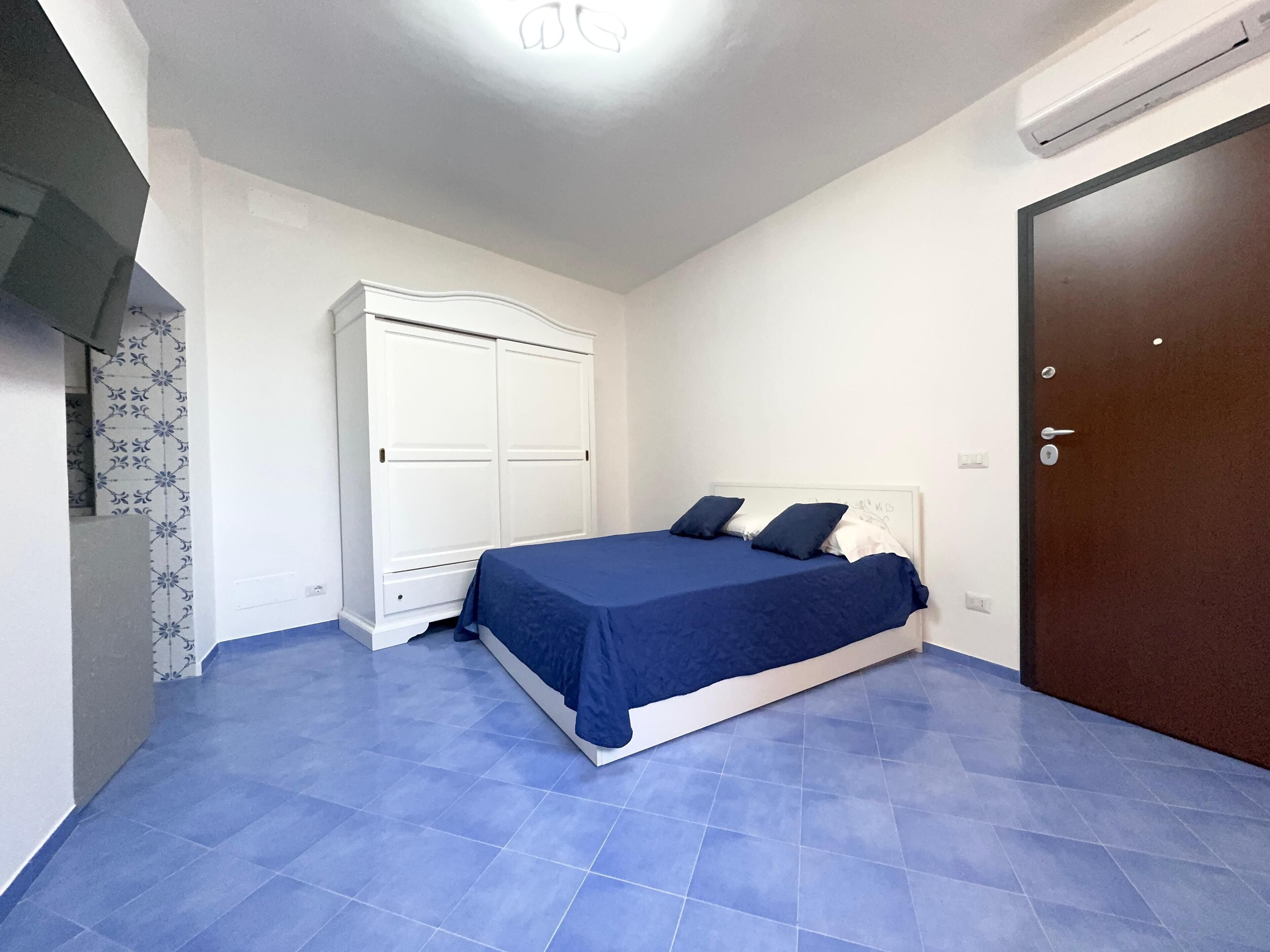 Un dormitorio con cama, armario y una puerta.