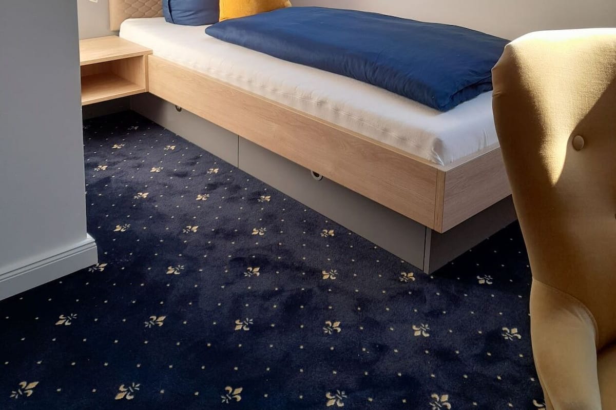 A compact bedroom with a bed, a desk, and a chair.