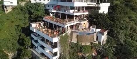 A multi-story building with a rooftop terrace and a pool.