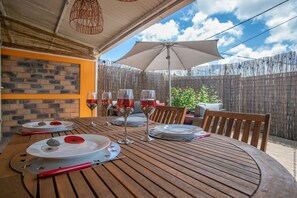 A wooden table set for a meal with plates, cutlery, and wine glasses. - The cocooning area (Saint-Joseph)