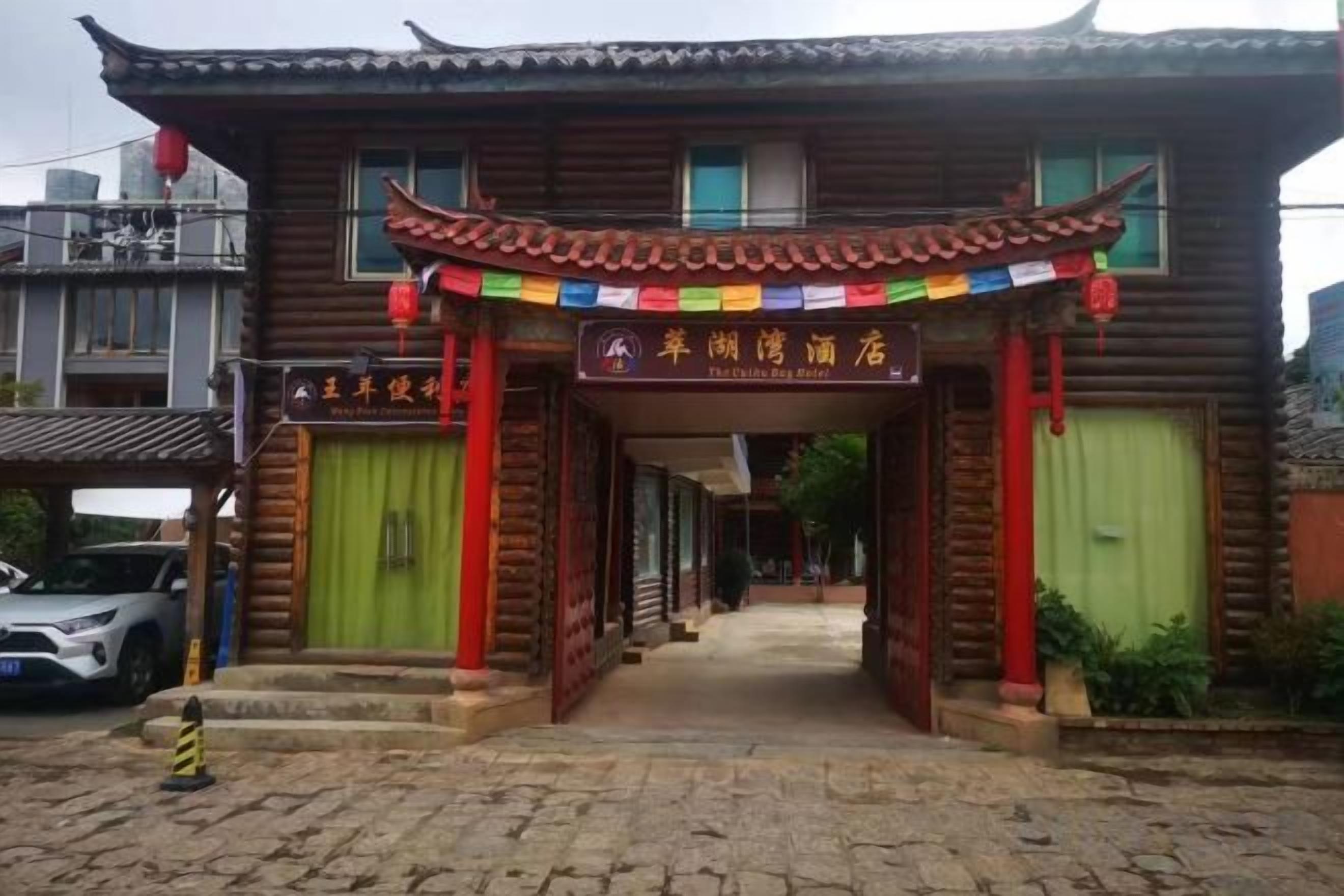 A traditional wooden building with a tiled roof, a green door, and a signboard.
