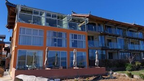 Un immeuble à plusieurs étages, doté de grandes fenêtres et de balcons, qui présente un mélange d’éléments architecturaux modernes et traditionnels.