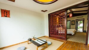 A traditional Japanese room with tatami flooring, a low wooden table, and a sliding door leading to a bedroom. - Dali Geothermal Paradise Hotel (Eryuan)