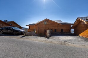 A wooden cabin with a car parked in front. - Chalet des Jonquilles - Magnifique maison avec piscine (Les Angles)