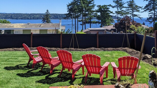 A patio with red chairs and a view of the water. - Cozy 2-bedroom, coastal inspired, suite with AC in beautiful Campbell River (Campbell River)
