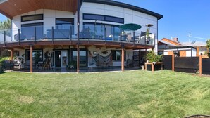 A modern two-story house with a balcony, a covered patio, and a well-maintained lawn. - Cozy 2-bedroom, coastal inspired, suite with AC in beautiful Campbell River (Campbell River)
