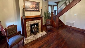 A room with a fireplace, a staircase, and a chandelier. - Historic Home within walking distance of Downtown Harmar & Marietta (Marietta)