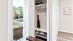 Un dressing avec des portes ouvertes, des étagères et un espace pour suspendre les vêtements.