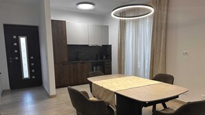 A modern kitchen with dark wood cabinets, a black countertop, and a built-in oven. - ROBI 2 Superior One-Bedroom Apartment with Terrace (veći) (Rovinj)