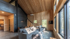 Et moderne interiør med en modulsofa, et spiseområde og store vinduer.