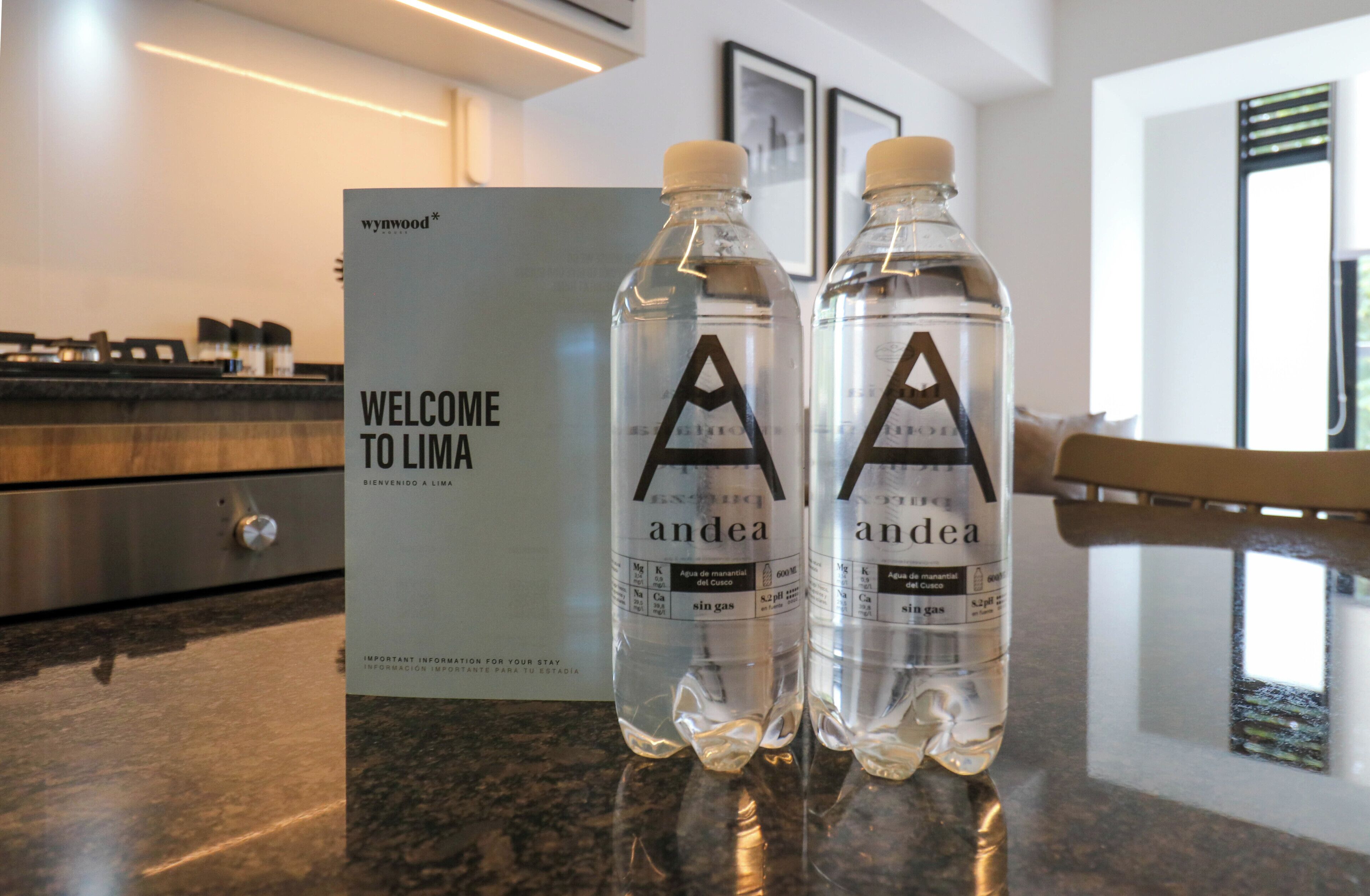 Two bottles of 'andea' water and a 'WELCOME TO LIMA' sign on a counter.