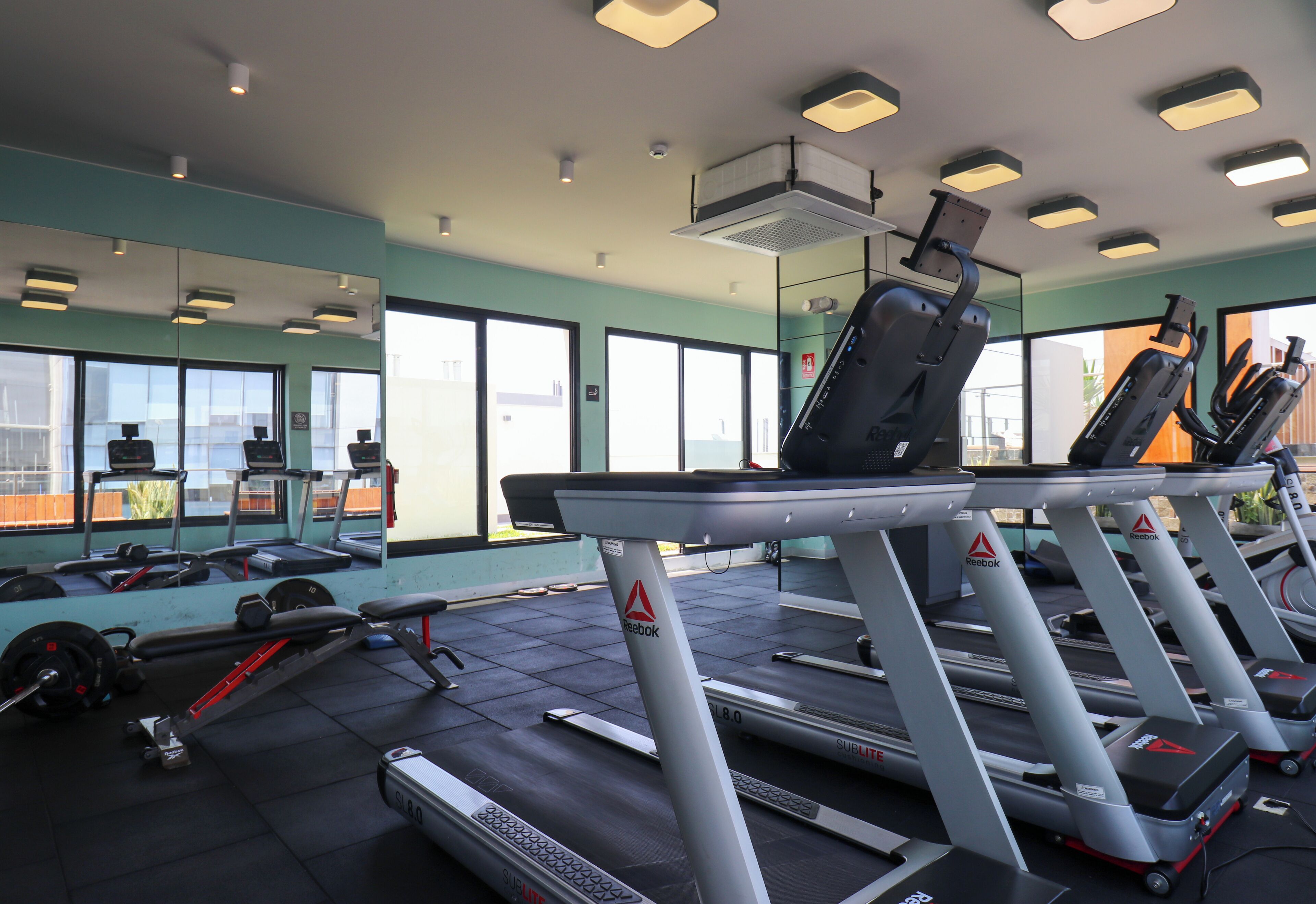 A gym with treadmills, weights, and exercise equipment.