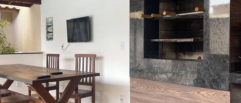 A modern kitchen with a built-in oven and a dining area with a wooden table and chairs.