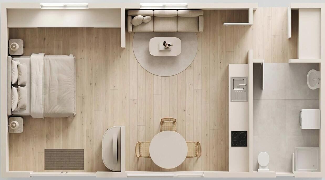 Habitación de hotel moderna con cama, una mesa redonda, un sofá, un pequeño rincón de cocina y un baño.