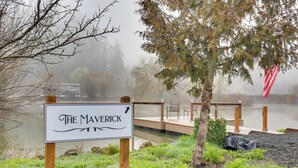 A sign for 'The Maverick' with a wooden deck and a lake in the background. - Private Pond & Dock! Cozy Cabin in Southern Oregon (Oakland)