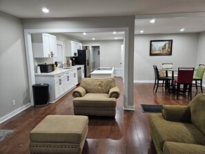 A modern living room with a sofa, ottoman, and a dining area with a table and chairs. - Charming 3-bedroom 2 bathroom house with WiFi, AC in marvelous Birmingham.. (Birmingham)
