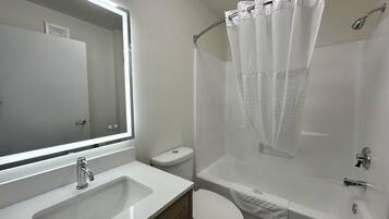 A bathroom with a sink, toilet, and bathtub.