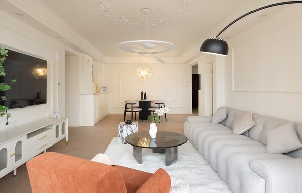 A modern living room with a sofa, a coffee table, and a TV. - Shanghai HUI B&B Near the Bund Xintiandi City View (Shanghai)