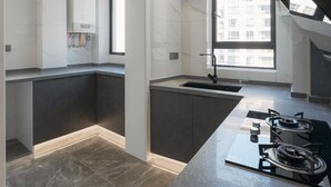 A modern kitchen with a central island, a built-in stove, and a window providing natural light. - Eastern Hub - Brand New Apartment, Walk to People Square, Bund, Yuyuan Garden (Shanghai,)