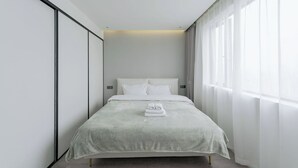 A minimalist hotel room with a bed, white curtains, and a view of the outside. - Eastern Hub - Brand New Apartment, Walk to People Square, Bund, Yuyuan Garden (Shanghai,)