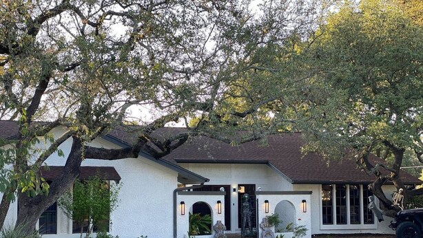A white house with a dark roof, a front porch, and a driveway. - Private King Studio | Near Domain & Apple (Austin)