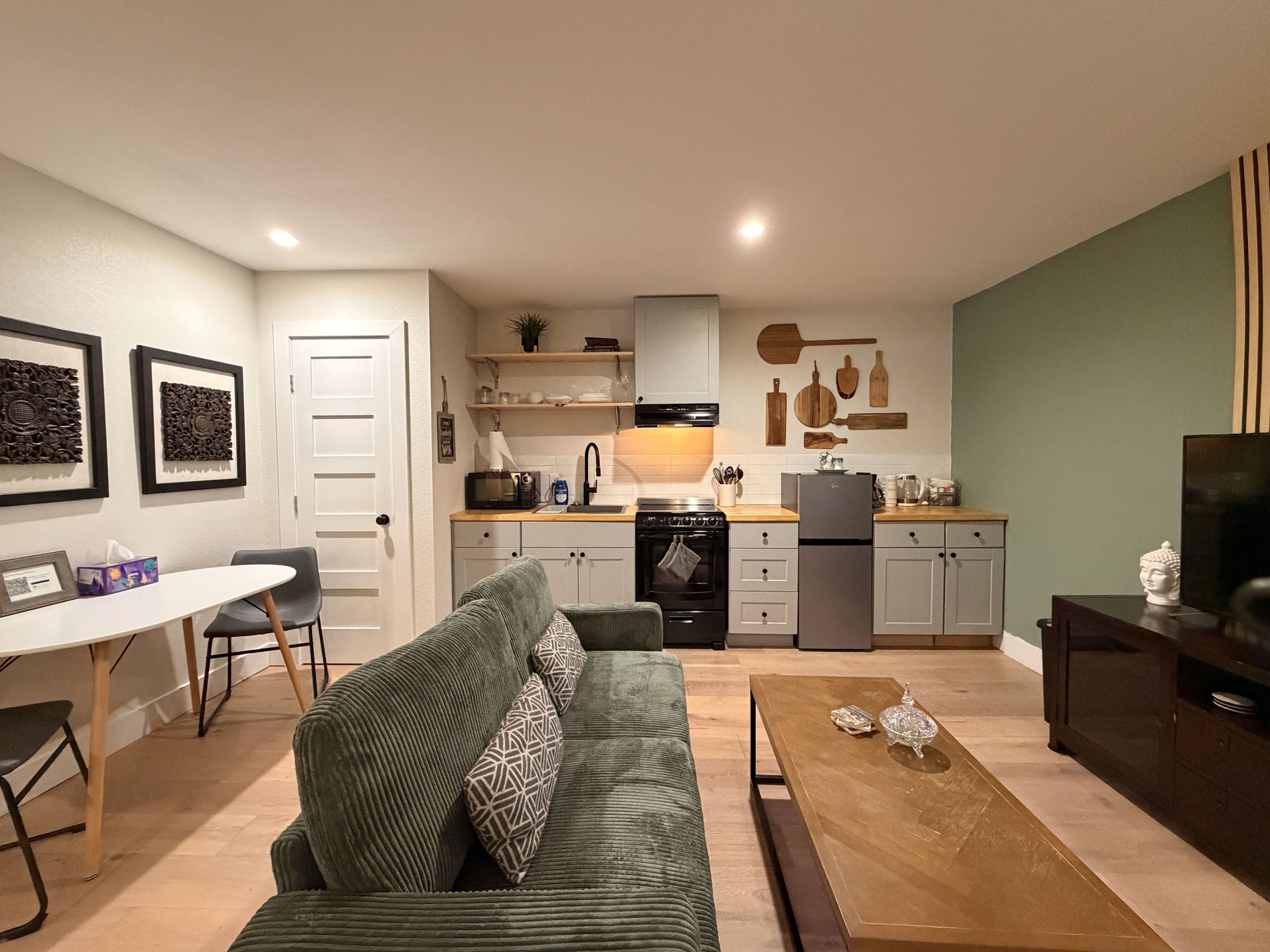 A compact living space with a kitchenette, a dining area, and a seating area with a sofa.
