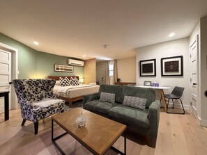 Een hotelkamer met een bed, een bank, een bijzettafeltje en een eethoek.
