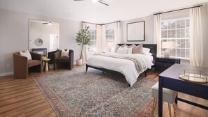 A bedroom with a bed, two armchairs, a desk, a ceiling fan, and large windows. - 5BR Cedar Park | Near HEB Center + Private Yard (Cedar Park)
