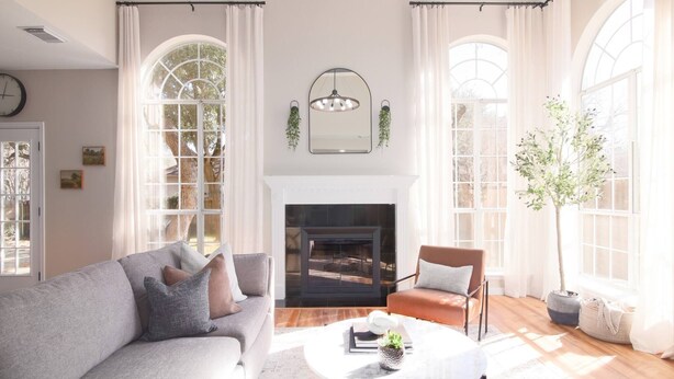 A living room with a fireplace, large windows, a sofa, a chair, and a coffee table. - 5BR Cedar Park | Near HEB Center + Private Yard (Cedar Park)