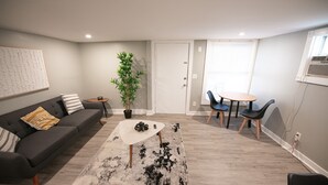 A modern living room with a sofa, coffee table, and dining area.