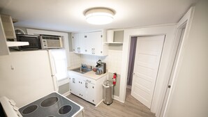 A compact kitchen with a stove, sink, and cabinets.