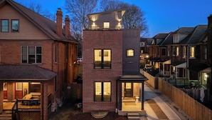 A modern two-story house with a brick facade, large windows, and a small front porch. - Rooftop Deck, Hot Tub, Speakeasy, Columbus Luxury (Columbus)