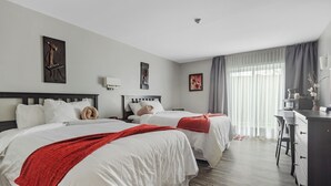 Een hotelkamer met twee bedden, een bureau en een stoel.