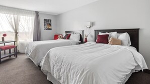 Een hotelkamer met twee bedden, een bureau en een stoel.