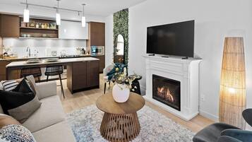 Open living room perspective showcasing direct sightlines to the electric fireplace surround and open kitchen.
