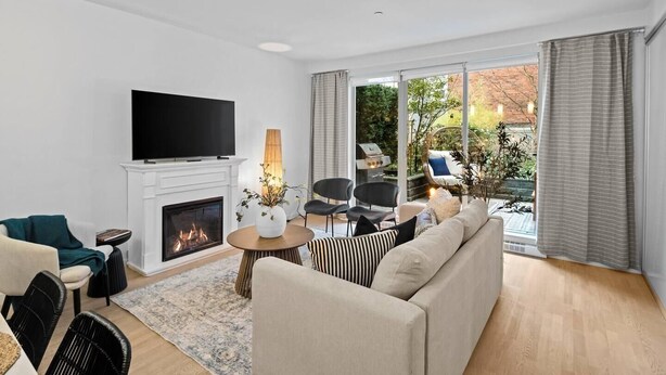 A modern living room with a fireplace, a flat-screen TV, and a large window with curtains. - Luxe King Bed and Private BBQ Terrace (Victoria North)