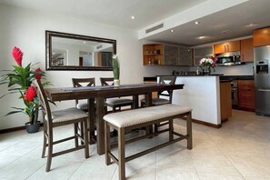 A modern kitchen with a dining area, featuring a wooden table, chairs, and a bench. - Simpson bay 3bdr / 3,5 bath with pools - GENERATOR (Simpson Bay)