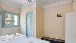 A hotel room with two beds, a door, a window, and a small picture on the wall. - Deluxe Double or Twin Room with Pyramids View (Giza Governorate)