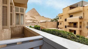 Un balcon avec vue sur une pyramide en arrière-plan.