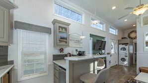 A kitchen with a bar area, built-in appliances, and a large window.