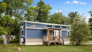 A two-story house with a wooden porch and a small deck.