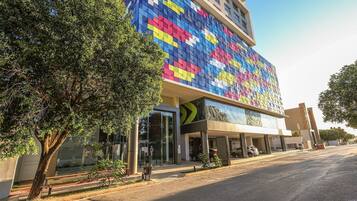 A modern building with a colorful facade, large windows, and a covered entrance area.