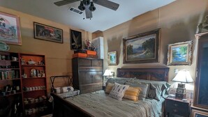 A bedroom with a bed, a nightstand, a dresser, a bookshelf, and a ceiling fan. - 1-bedroom/bath Cozy rustic cottage, off the RCR with AC in lovely Wrinkler, Tx.  (Streetman)