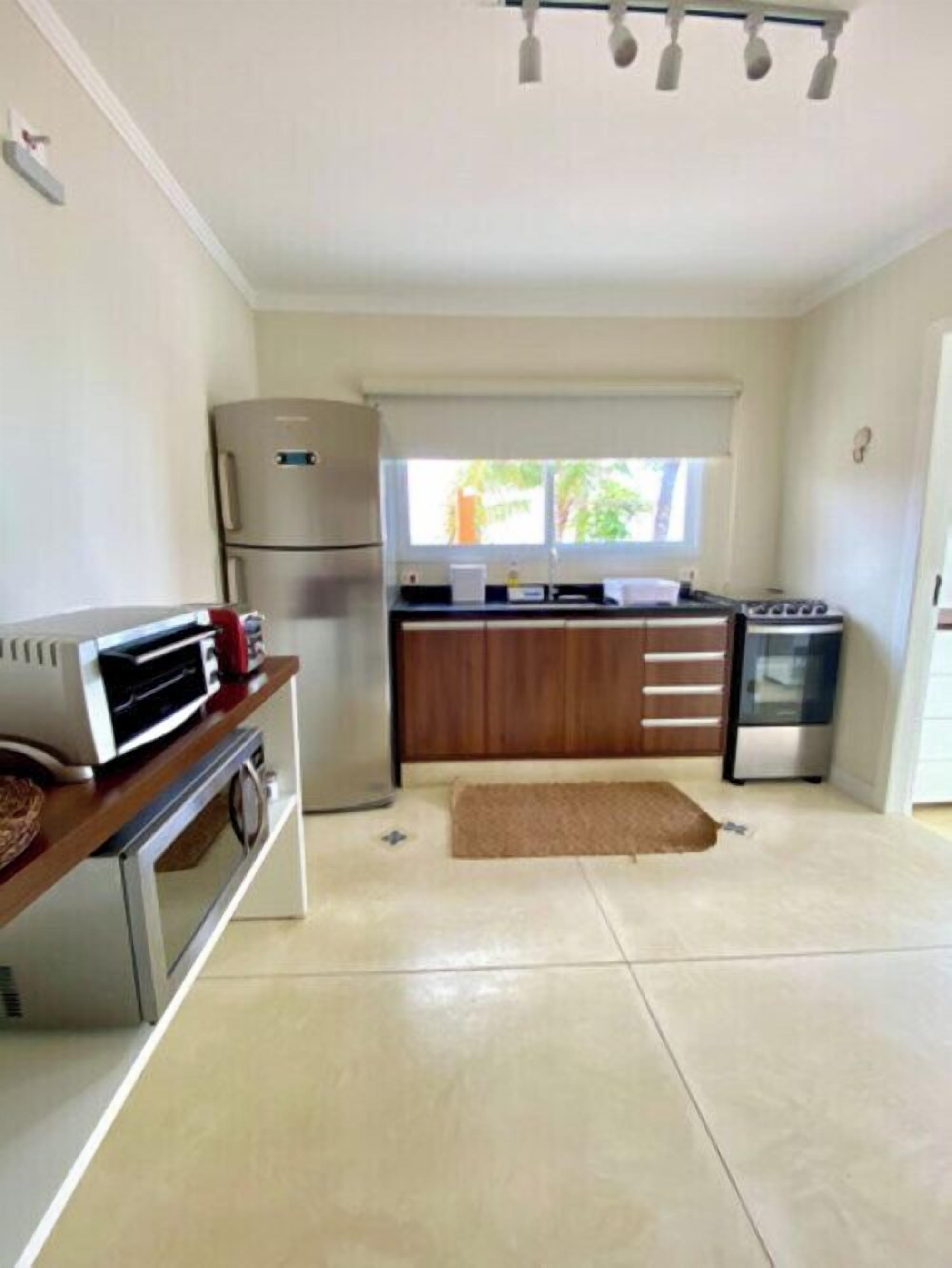 Eine kompakte Küche mit Kühlschrank, Backofen, Mikrowelle und Herd.