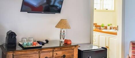 A living area with a wooden cabinet, a television, and a small refrigerator.