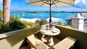 Ein Balkon mit Tisch und Stühlen mit Blick auf einen Yachthafen und Boote.