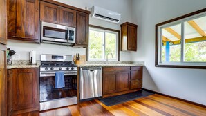 A kitchen with wooden cabinets, stainless steel appliances, and a large window.
