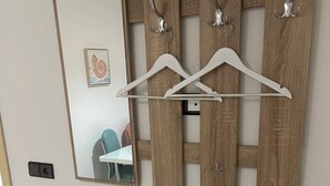 Une salle de bain moderne avec un meuble-lavabo en bois, un miroir et un porte-vêtements suspendu.
