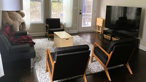 A living room with a sofa, two armchairs, a coffee table, a TV, and a window with curtains. - Spacious 4-bedroom townhome with WiFi, AC in terrific Fort Mill (Fort Mill)